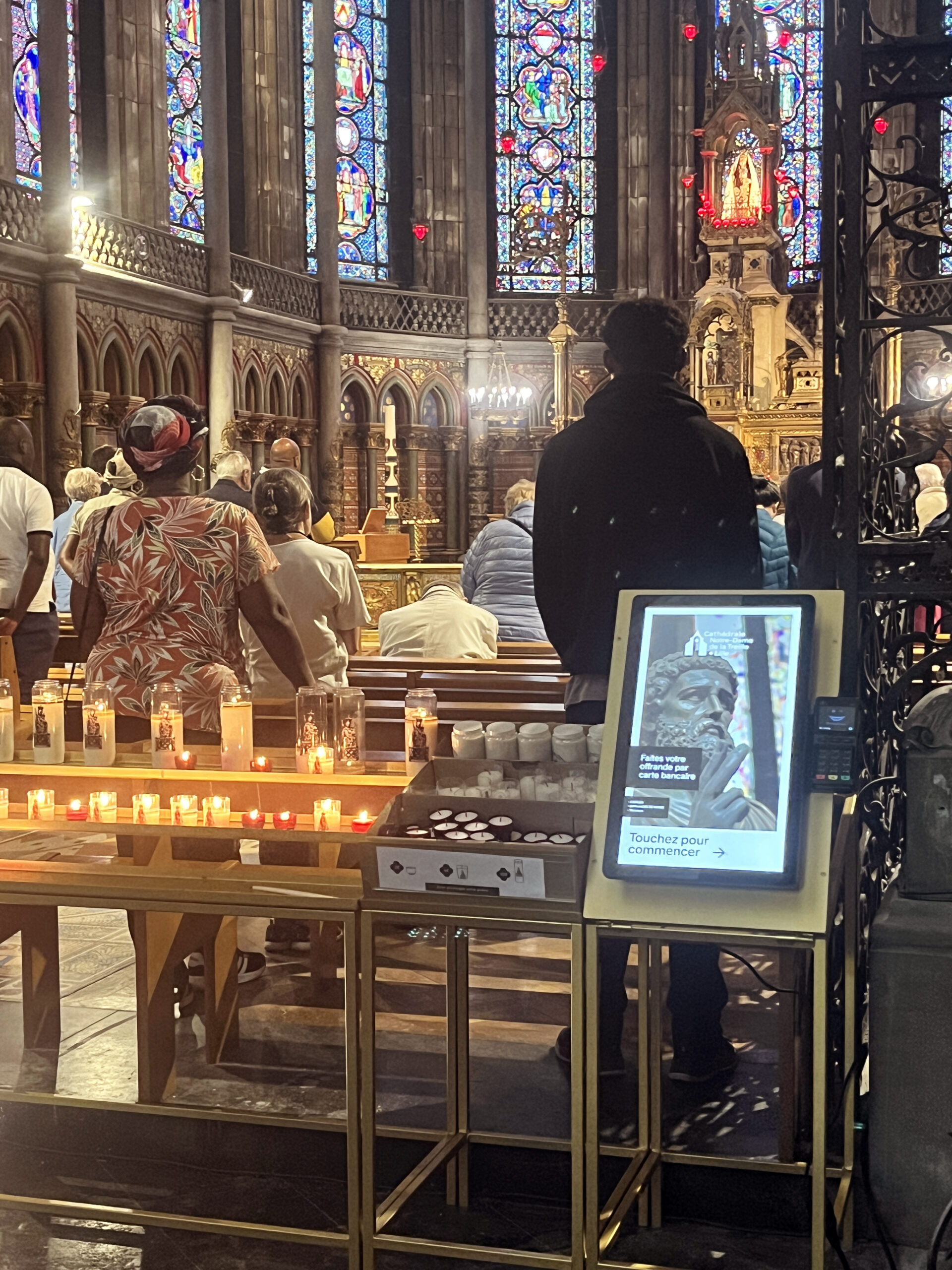 Borne de dons 6xPOS installée dans une église avec fidèles en prière